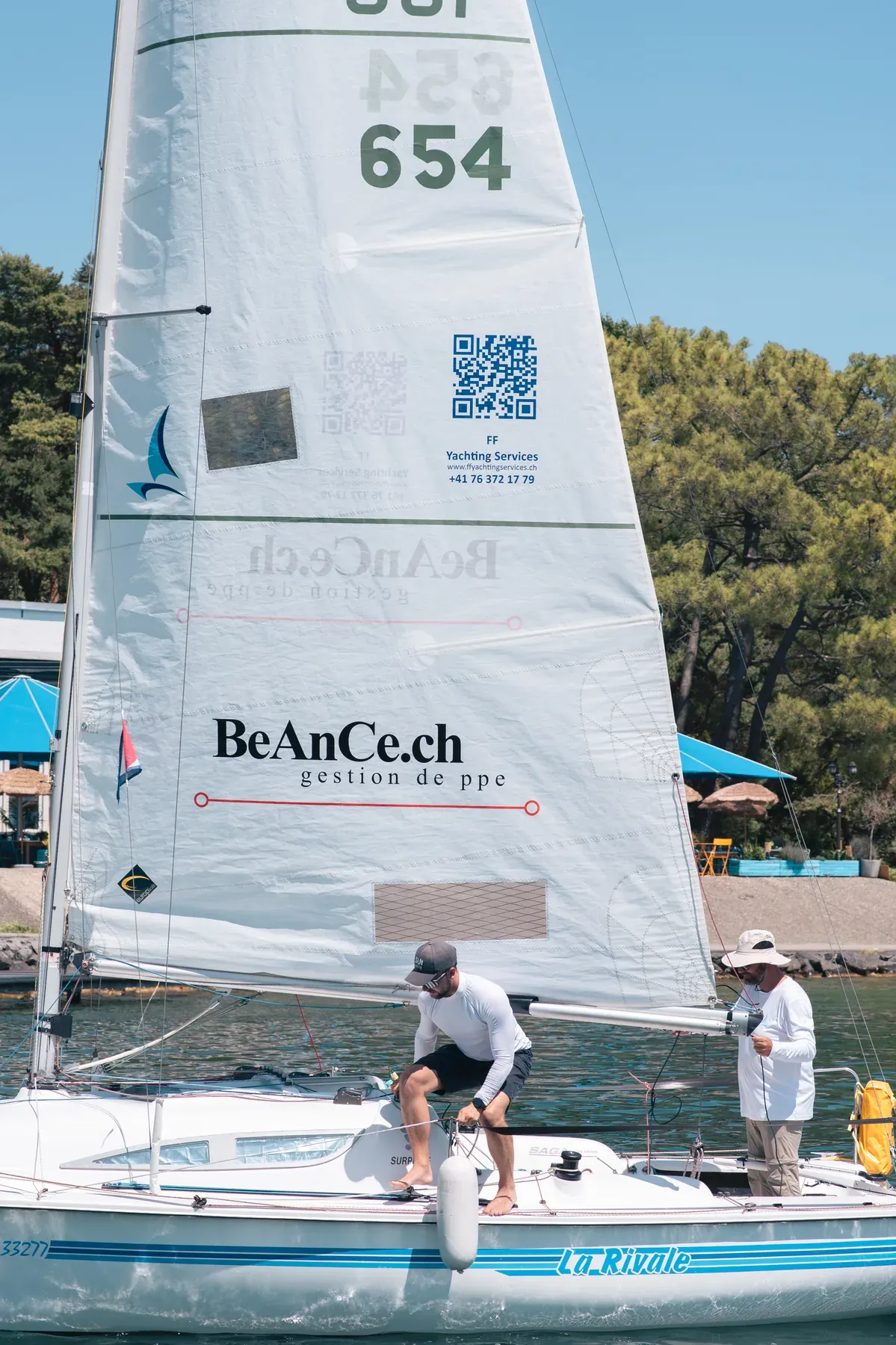 F. et E. Fischlin préparant La Rivale 3, avec les partenaires Beance et FF Yachting Services visibles sur la voile